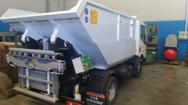 Isuzu NLR85 L35 con vasca ribaltabile, vista posteriore con sistema di carico in officina