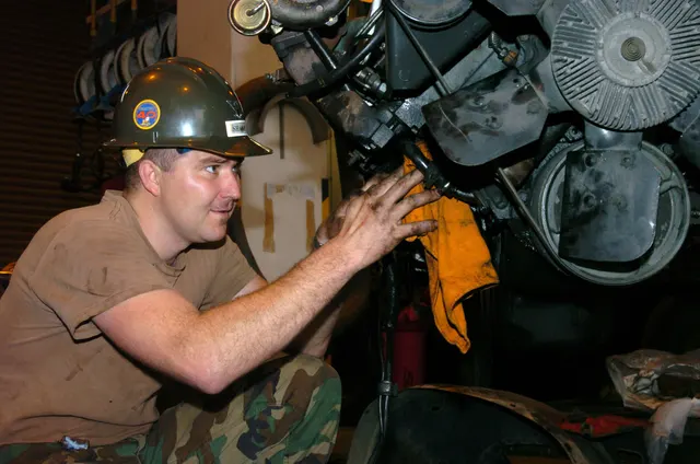 Meccanico al lavoro sul motore di un autocarro, riparazioni meccaniche su veicoli industriali